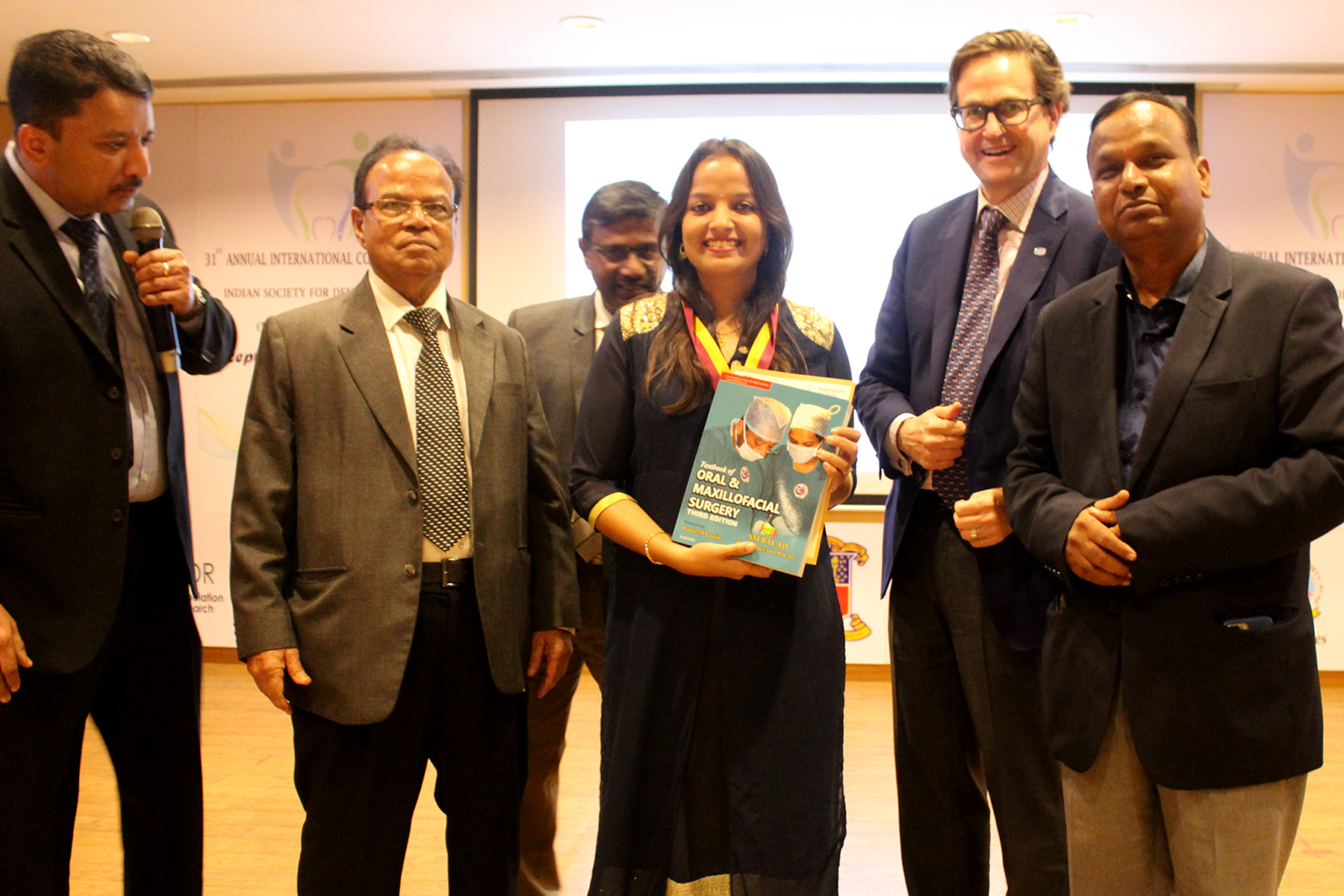 A top ranker being presented with Dr SM Balaji’s Textbook of Oral and Maxillofacial Surgery